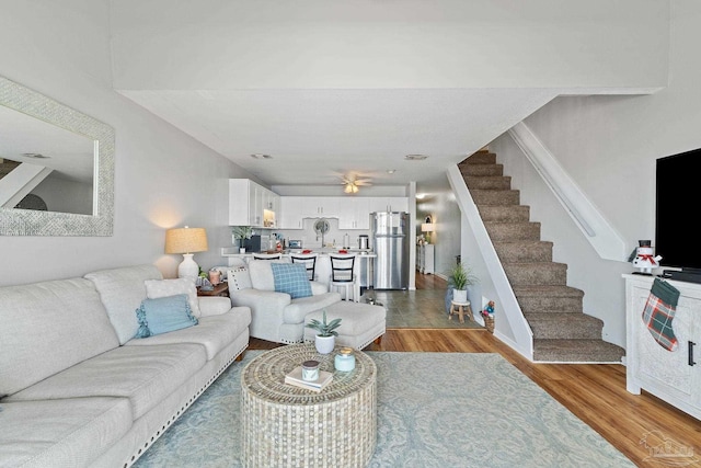 living area featuring light wood-type flooring and stairs