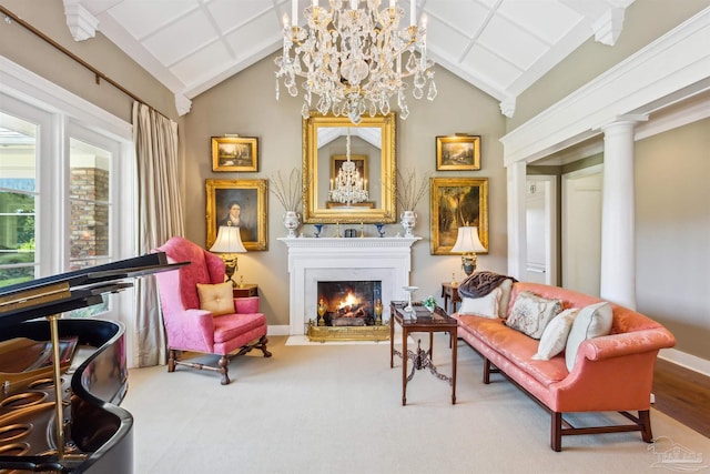 living area featuring a notable chandelier, vaulted ceiling, and ornate columns