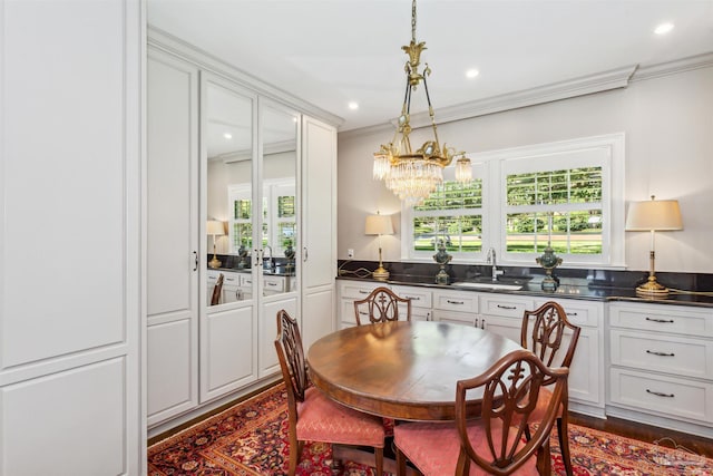 dining room with dark wood-type flooring, ornamental molding, plenty of natural light, and sink