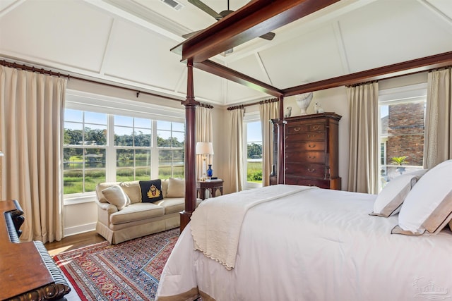 bedroom with lofted ceiling with beams and wood-type flooring