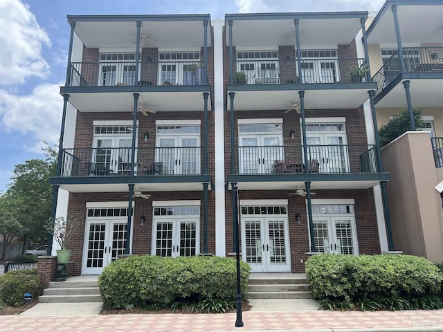 view of front facade featuring ceiling fan, french doors, and a balcony