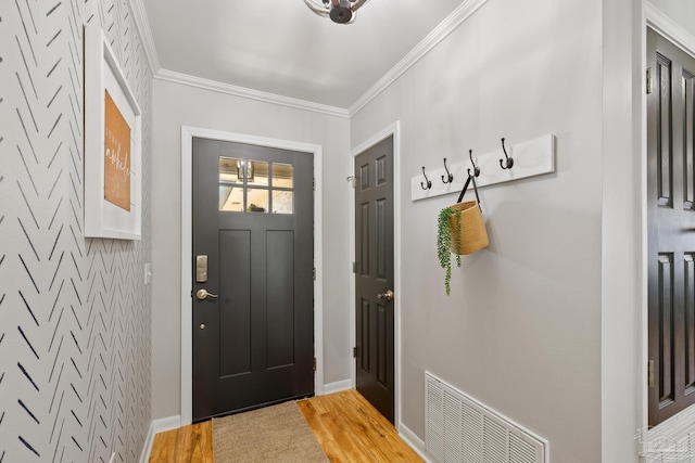 interior space with visible vents, baseboards, light wood-style floors, and ornamental molding