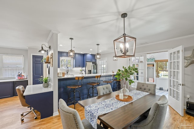 dining space with crown molding and light wood-style floors