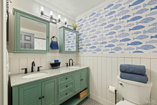 full bath featuring toilet, ornamental molding, wainscoting, and a sink