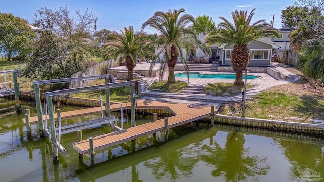 view of dock with a patio, a fenced backyard, an outdoor pool, and a water view