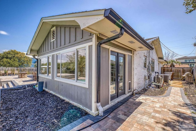 view of home's exterior featuring a patio area, board and batten siding, and fence