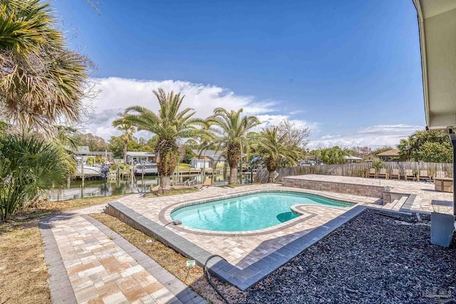 view of swimming pool with a water view, a fenced backyard, a dock, a fenced in pool, and a patio area