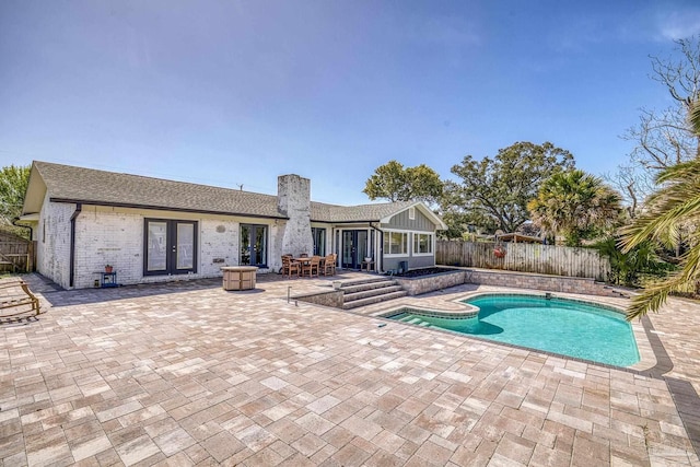 view of swimming pool featuring a patio, french doors, a fenced in pool, and a fenced backyard