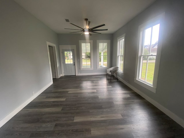 empty room with ceiling fan and dark wood-type flooring