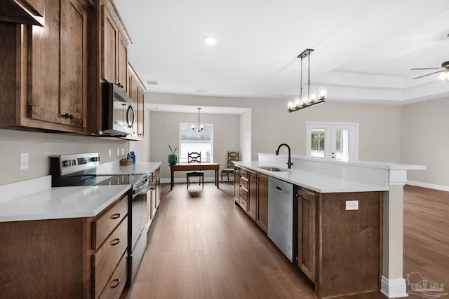 5681 Paddlewheel Dr, Milton, FL 32583 - kitchen with appliances with stainless steel finishes, wood finished floors, a sink, light countertops, and ceiling fan