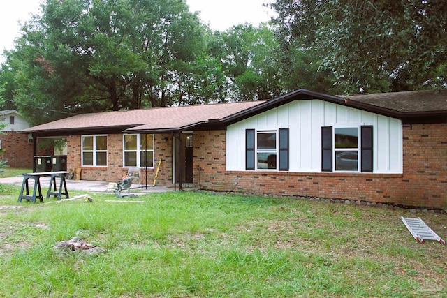 ranch-style house featuring a front lawn and a patio