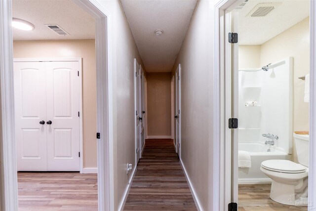 hallway with hardwood / wood-style floors