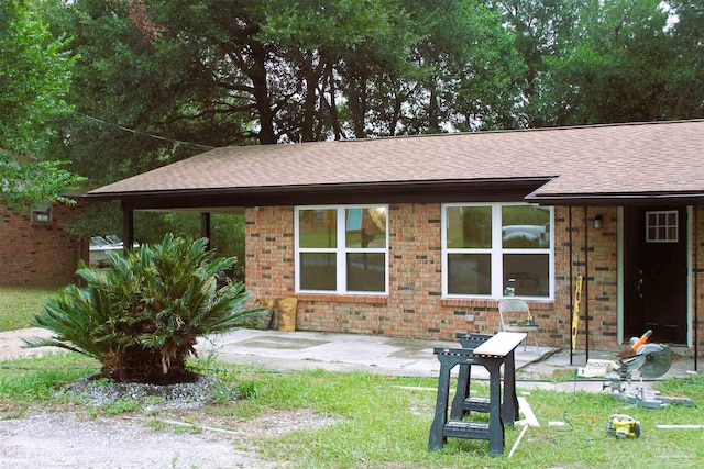 single story home with a front lawn and a patio area