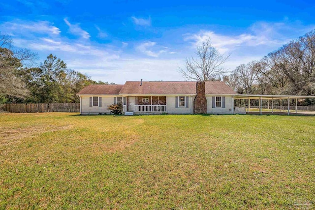 view of front facade with covered porch, a carport, a front yard, and fence