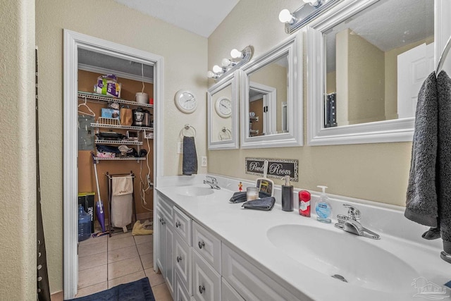 bathroom featuring tile patterned flooring, a sink, a spacious closet, and double vanity