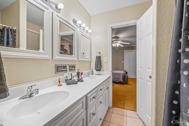 ensuite bathroom featuring ceiling fan, tile patterned flooring, a sink, and double vanity