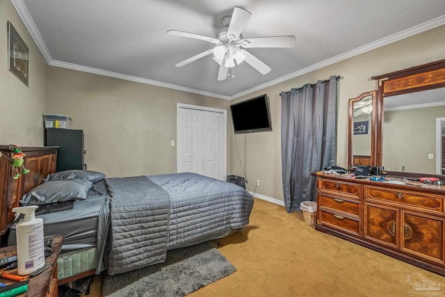 bedroom featuring baseboards, ceiling fan, ornamental molding, carpet flooring, and a closet