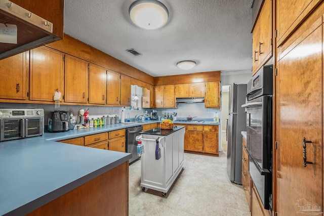 kitchen with brown cabinetry, visible vents, dishwasher, and under cabinet range hood