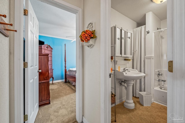 bathroom with bathtub / shower combination, connected bathroom, a textured ceiling, and baseboards