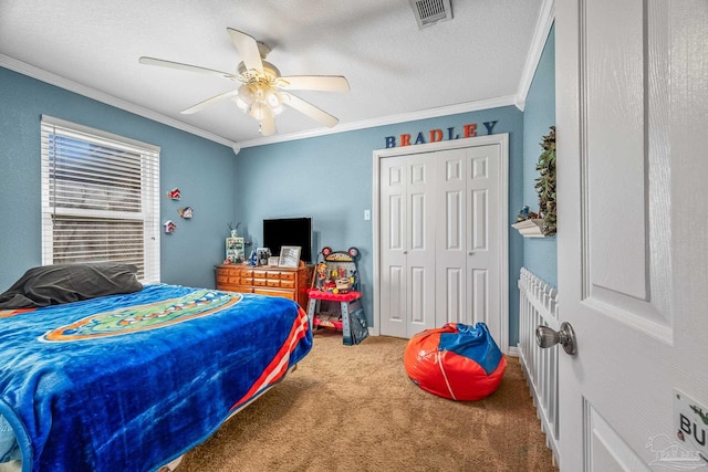 bedroom featuring visible vents, ornamental molding, carpet, a textured ceiling, and a closet