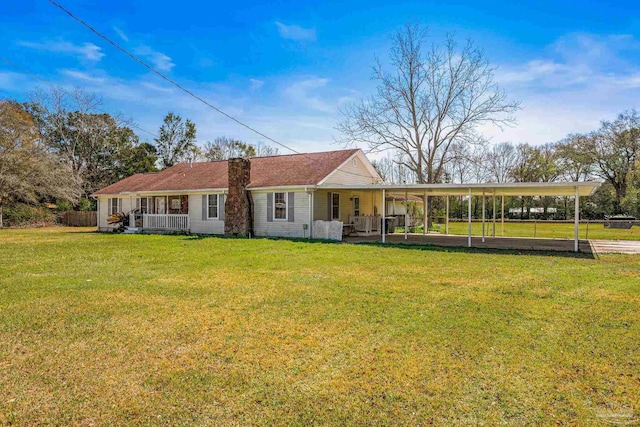 rear view of property with a yard and fence