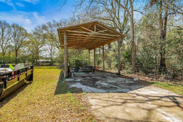 view of yard featuring fence, concrete driveway, and a detached carport