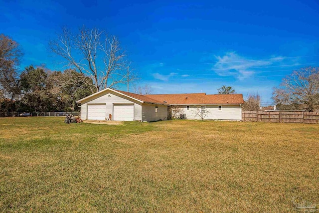 exterior space with driveway, a lawn, an attached garage, and fence