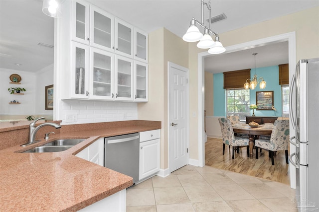 kitchen featuring light tile patterned floors, a sink, visible vents, white cabinetry, and appliances with stainless steel finishes