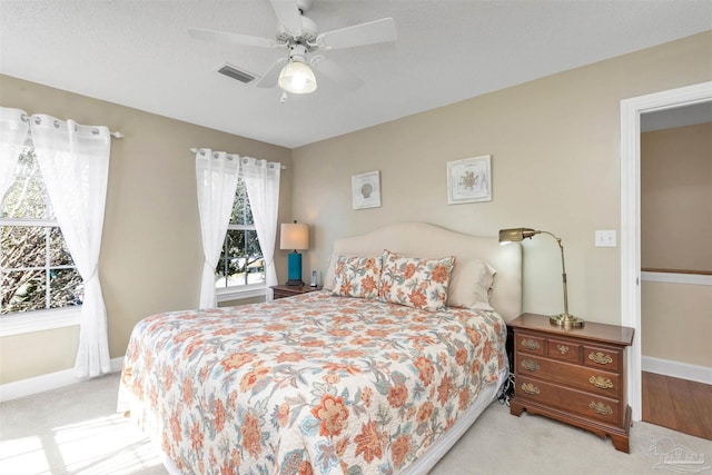 carpeted bedroom featuring ceiling fan, visible vents, and baseboards