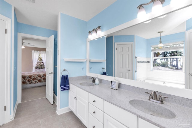 ensuite bathroom featuring double vanity, tile patterned floors, a sink, and connected bathroom