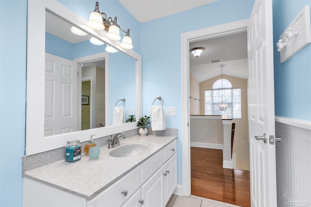 bathroom featuring vaulted ceiling, a notable chandelier, vanity, and tile patterned floors