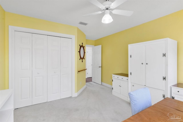 unfurnished bedroom with a closet, light colored carpet, visible vents, a ceiling fan, and baseboards