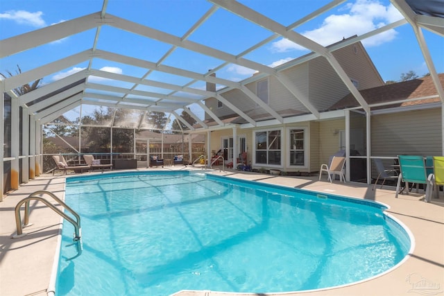 outdoor pool featuring glass enclosure and a patio area