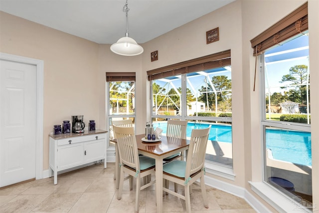 dining area with light tile patterned floors, a sunroom, and baseboards