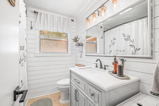 bathroom with vanity, wood walls, a shower with curtain, tile patterned flooring, and toilet