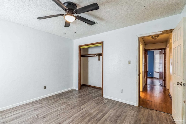 unfurnished bedroom featuring hardwood / wood-style floors, ceiling fan, a textured ceiling, and a closet