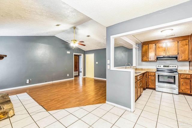 kitchen featuring a textured ceiling, light hardwood / wood-style flooring, vaulted ceiling, and stainless steel electric range