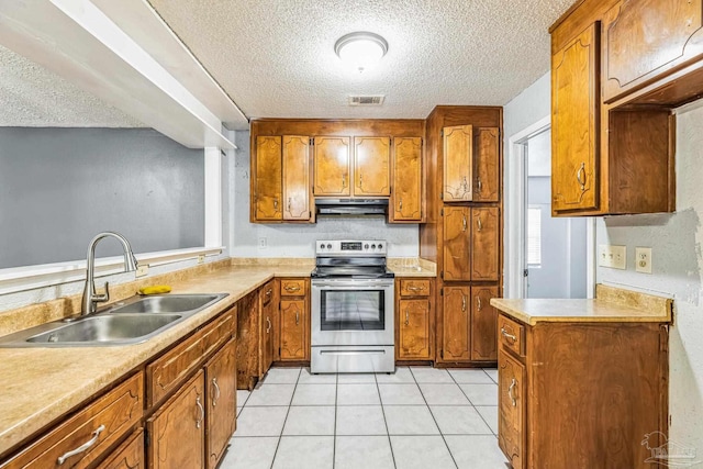 kitchen with electric range, light tile patterned floors, sink, and a textured ceiling