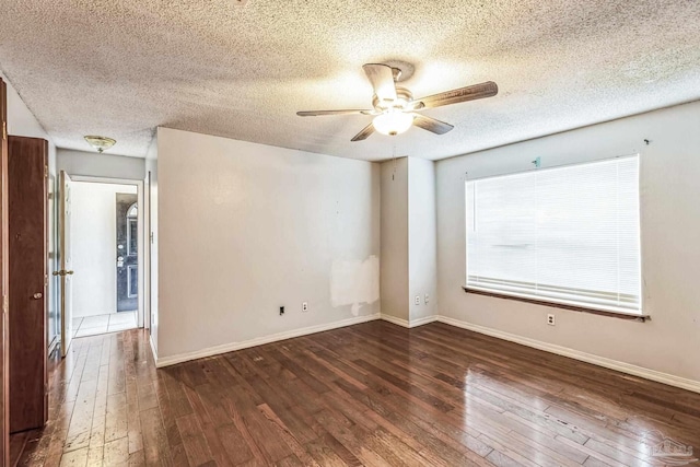 empty room featuring a textured ceiling, ceiling fan, and dark wood-type flooring