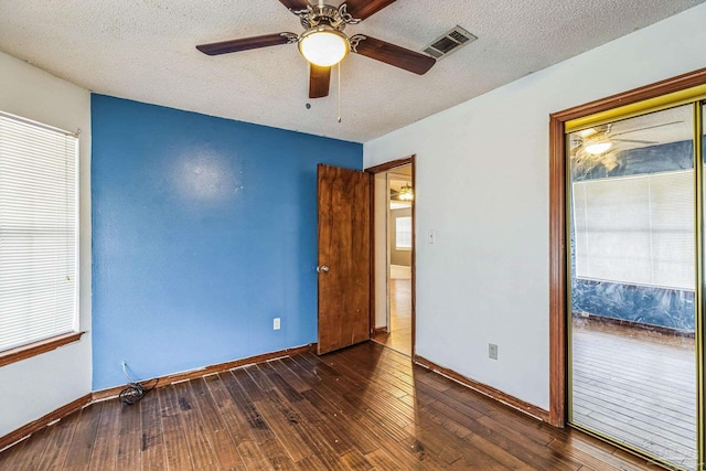 unfurnished bedroom with dark hardwood / wood-style floors, ceiling fan, and a textured ceiling