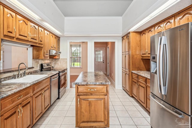 kitchen featuring a center island, light tile patterned flooring, sink, decorative backsplash, and appliances with stainless steel finishes