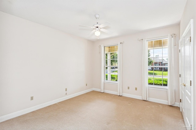 carpeted spare room with ceiling fan