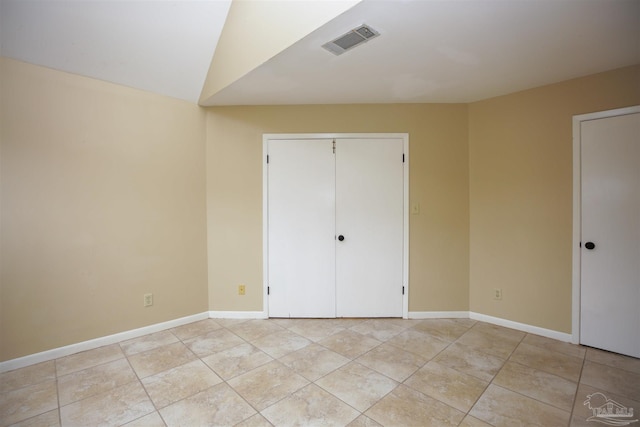 unfurnished bedroom featuring a closet and vaulted ceiling