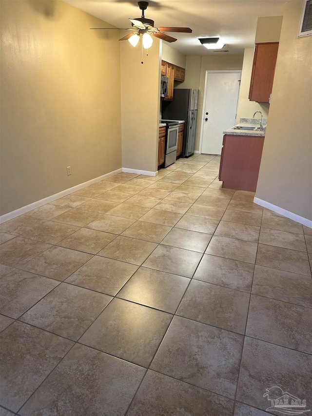 unfurnished living room with ceiling fan and sink