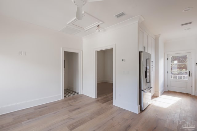 empty room with light wood-style floors, attic access, visible vents, and baseboards