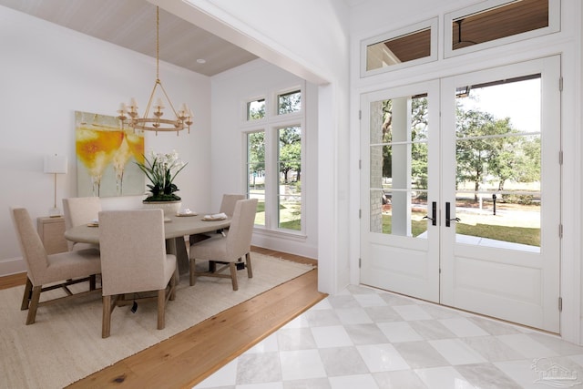 interior space with light floors, french doors, a wealth of natural light, and a notable chandelier