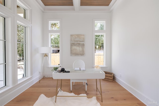 home office featuring light wood-style floors, baseboards, coffered ceiling, and beam ceiling