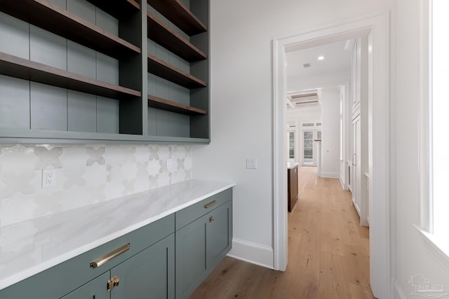 interior space featuring light wood finished floors, tasteful backsplash, and baseboards