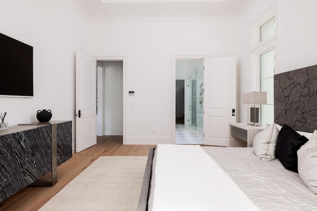 bedroom featuring ornamental molding, baseboards, and light wood finished floors