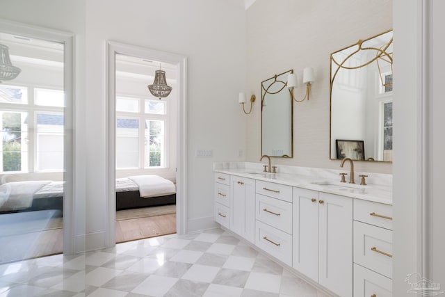 ensuite bathroom featuring a sink, double vanity, ensuite bath, and tile patterned floors